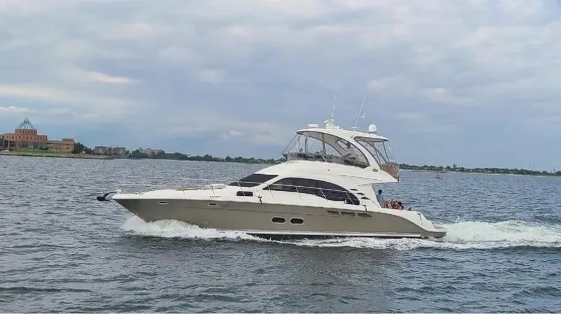 Slide: The Image of 2006 Sea Ray 52 Sedan Bridge yacht cruising on open water under cloudy skies. - 11