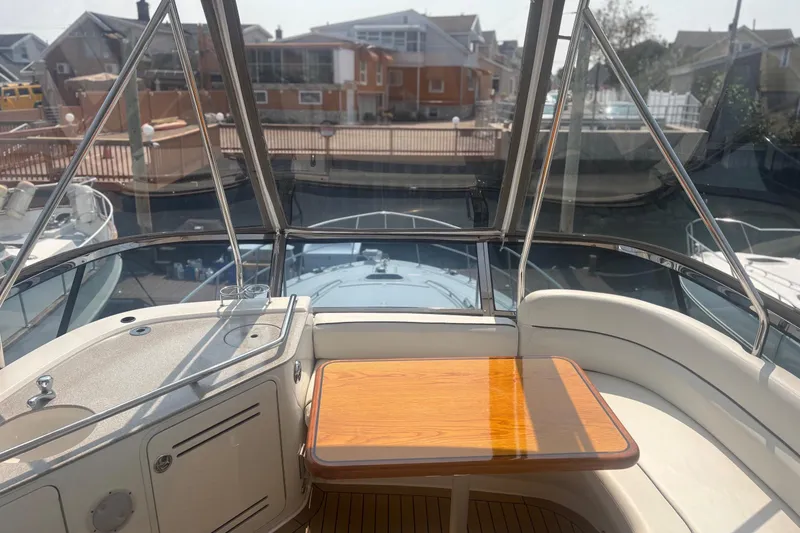 Slide: The Image of 2006 Sea Ray 52 Sedan Bridge yacht interior with wooden table and seating area. - 14