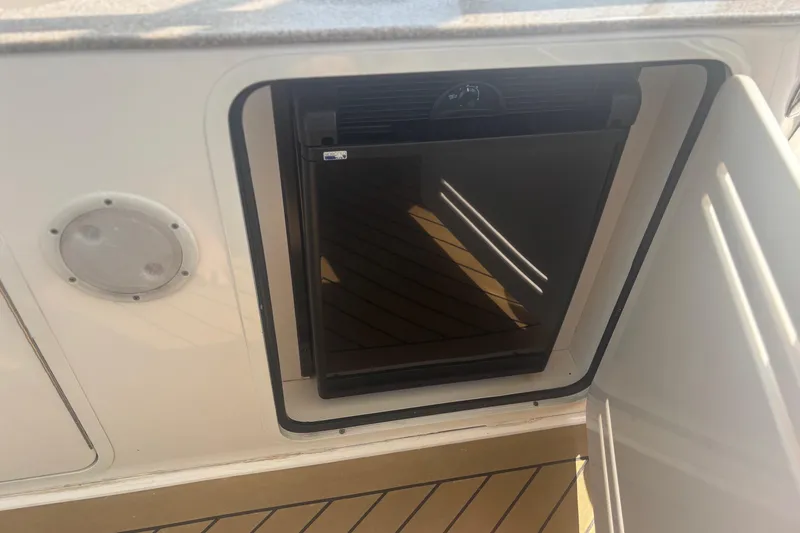 Slide: The Image of Mini fridge on 2006 Sea Ray 52 Sedan Bridge yacht, open door, wooden deck. - 16