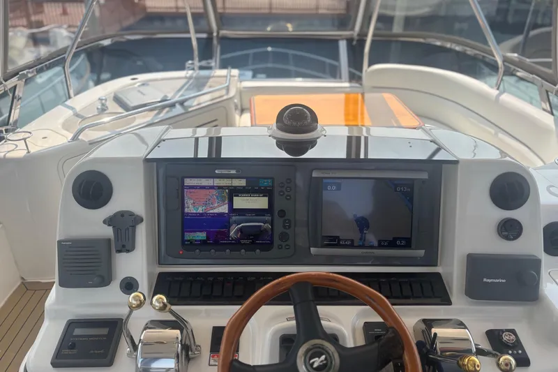 Slide: The Image of 2006 Sea Ray 52 Sedan Bridge helm with navigation screens and controls. - 19