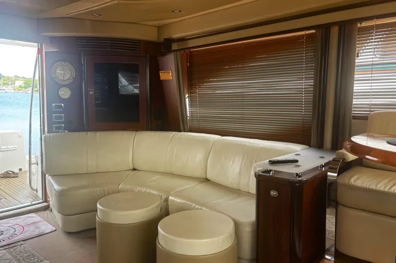 Slide: The Image of Interior of 2006 Sea Ray 52 Sedan Bridge yacht with leather seating and wooden table. - 34
