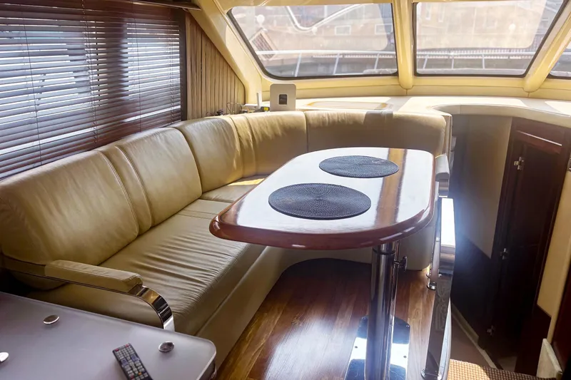 Slide: The Image of Luxurious interior of 2006 Sea Ray 52 Sedan Bridge yacht with leather seating and wooden table. - 35