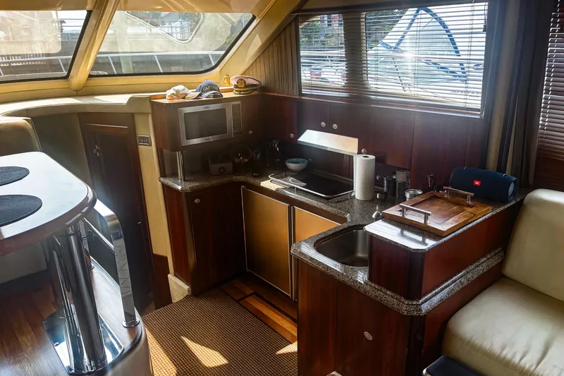 Slide: The Image of Luxurious interior of 2006 Sea Ray 52 Sedan Bridge yacht with modern kitchen and seating area. - 38