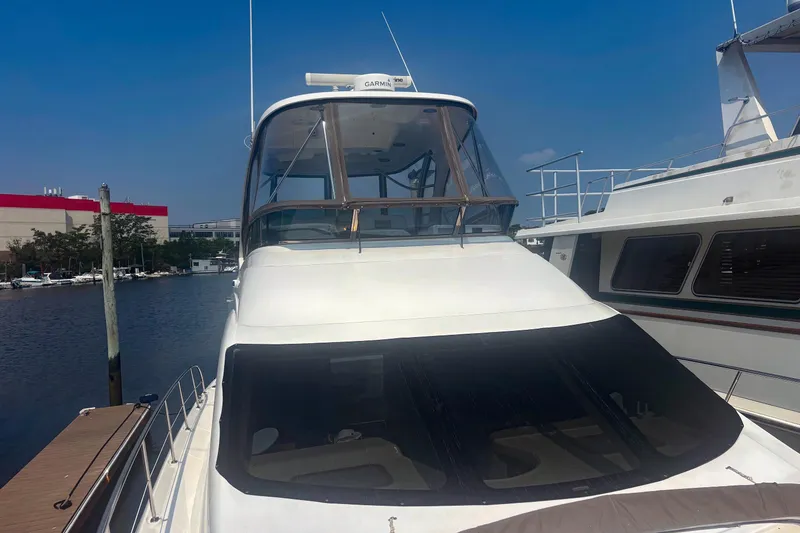 Slide: The Image of 2006 Sea Ray 52 Sedan Bridge yacht docked at marina under clear blue sky. - 4