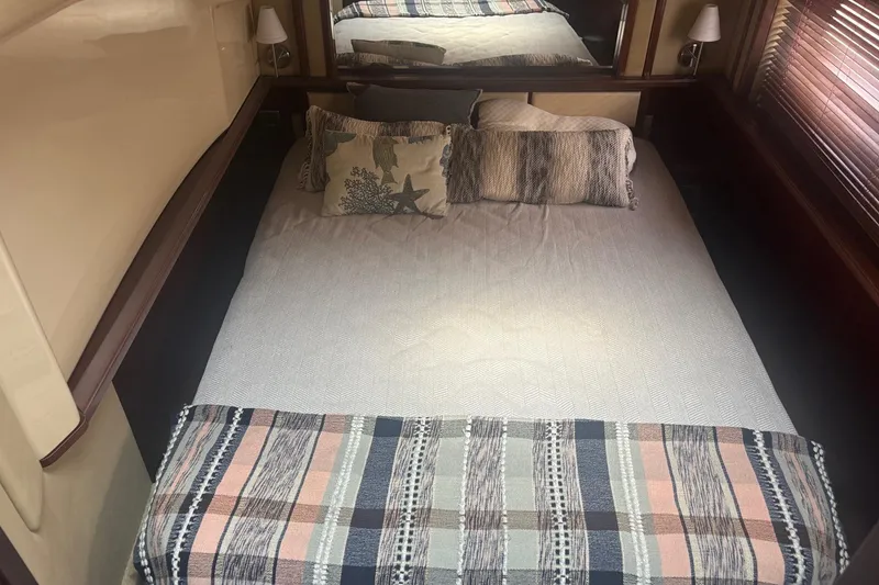 Slide: The Image of Cozy bedroom interior of 2006 Sea Ray 52 Sedan Bridge yacht with decorative pillows and blanket. - 42