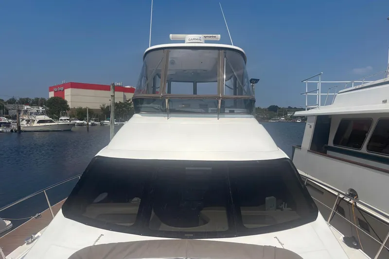 Slide: The Image of 2006 Sea Ray 52 Sedan Bridge yacht docked at marina under clear blue sky. - 5