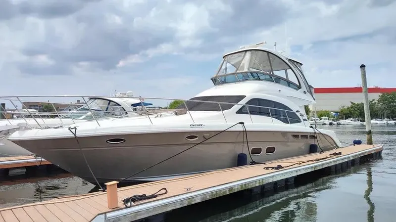 Slide: The Image of 2006 Sea Ray 52 Sedan Bridge yacht docked at marina under cloudy sky. - 6