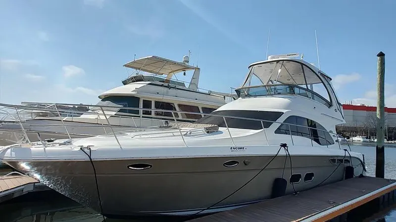 Slide: The Image of 2006 Sea Ray 52 Sedan Bridge yacht docked at marina under clear blue sky. - 7