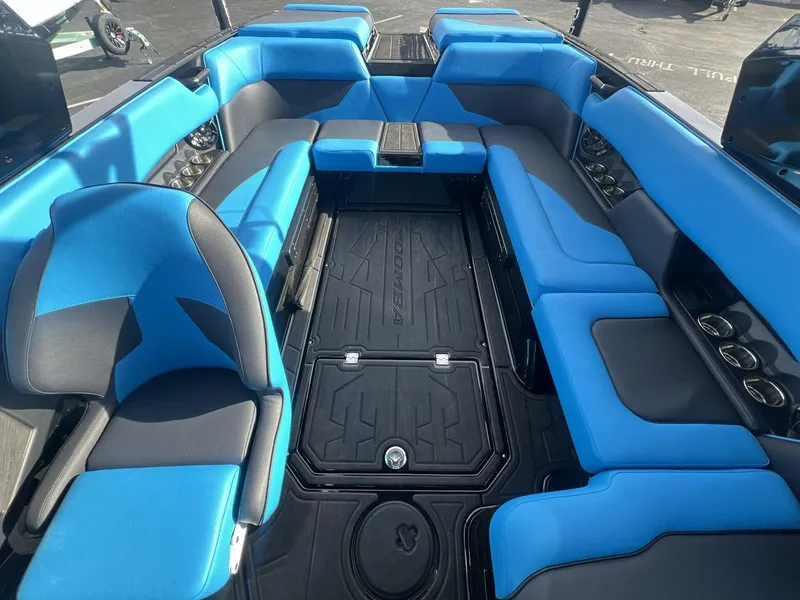 Slide: The Image of 2025 Moomba Mojo boat interior with blue and black seating, spacious layout, and modern design. - 10