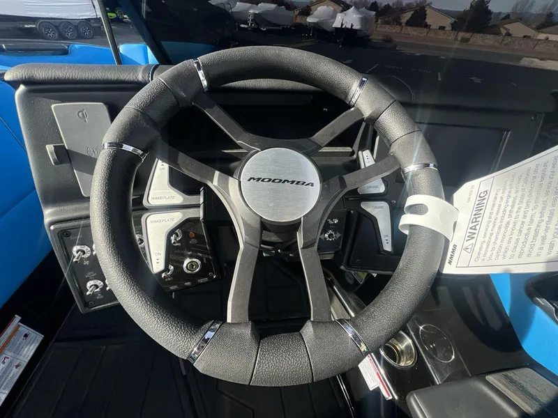 Slide: The Image of 2025 Moomba Mojo steering wheel with control buttons and warning label. - 14