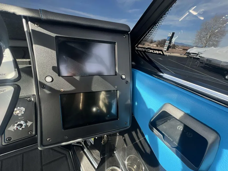 Slide: The Image of 2025 Moomba Mojo boat dashboard with dual screens and wireless charging pad. - 15