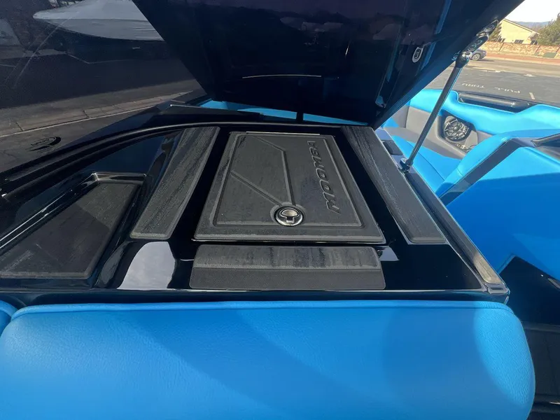 Slide: The Image of 2025 Moomba Mojo boat engine compartment with open hatch, showcasing sleek design and blue interior. - 18