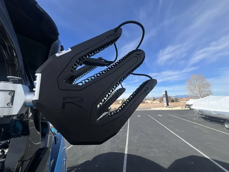 Slide: The Image of 2025 Moomba Mojo boat with R Elite II wakeboard rack under clear blue sky. - 22