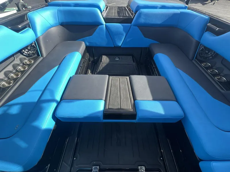 Slide: The Image of 2025 Moomba Mojo boat interior with blue and black seating and cup holders. - 23