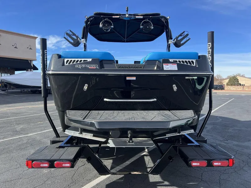 Slide: The Image of 2025 Moomba Mojo boat rear view with Raptor engine, parked on a trailer. - 4