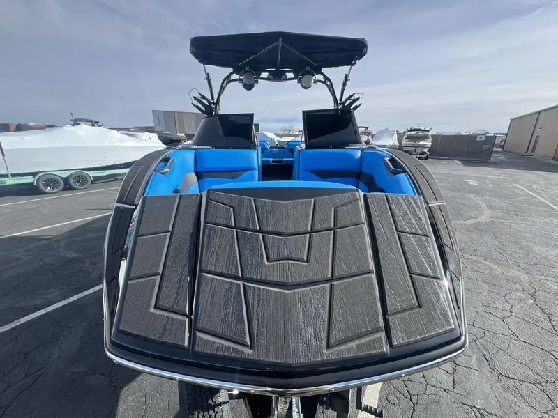 Slide: The Image of 2025 Moomba Mojo boat with blue interior and sleek design, parked outdoors. - 8