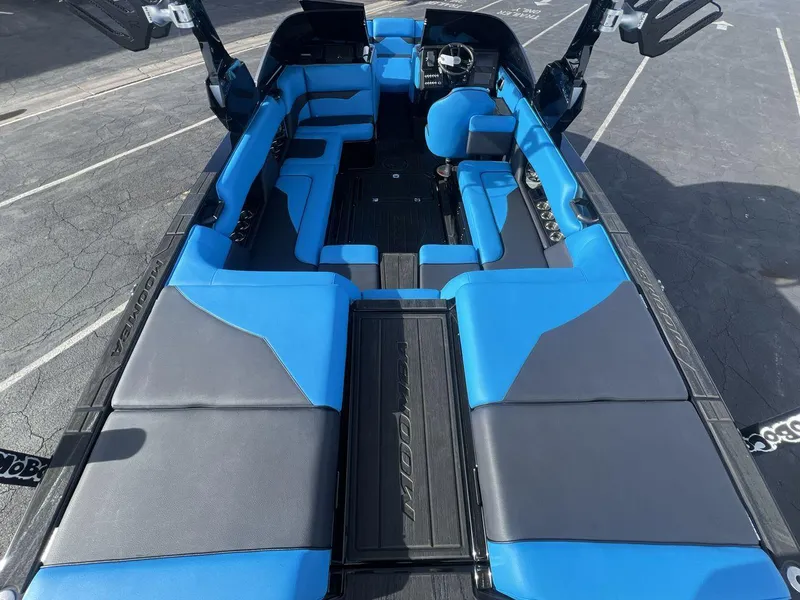 Slide: The Image of 2025 Moomba Mojo boat interior with blue and gray seating, showcasing modern design and spacious layout. - 9