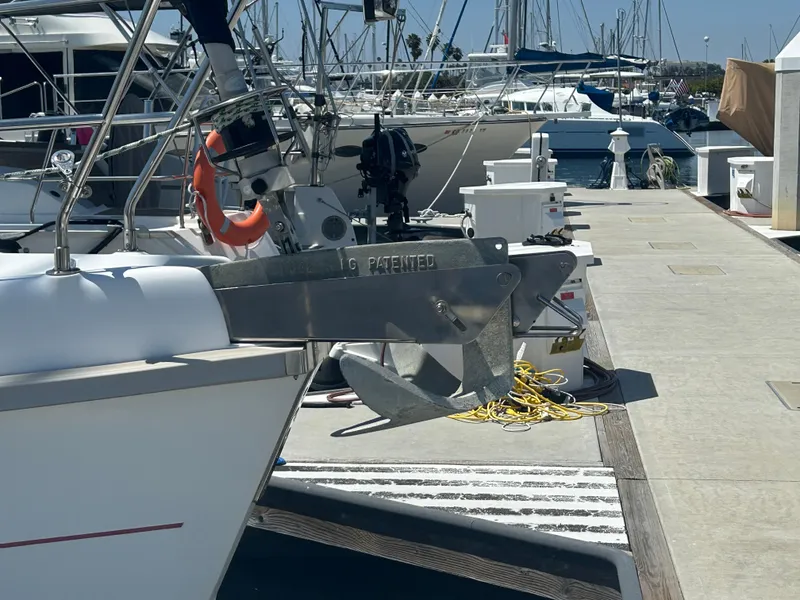 Slide: The Image of 1998 Hunter Passage 450 sailboat docked, featuring anchor and lifebuoy, in a marina setting. - 15