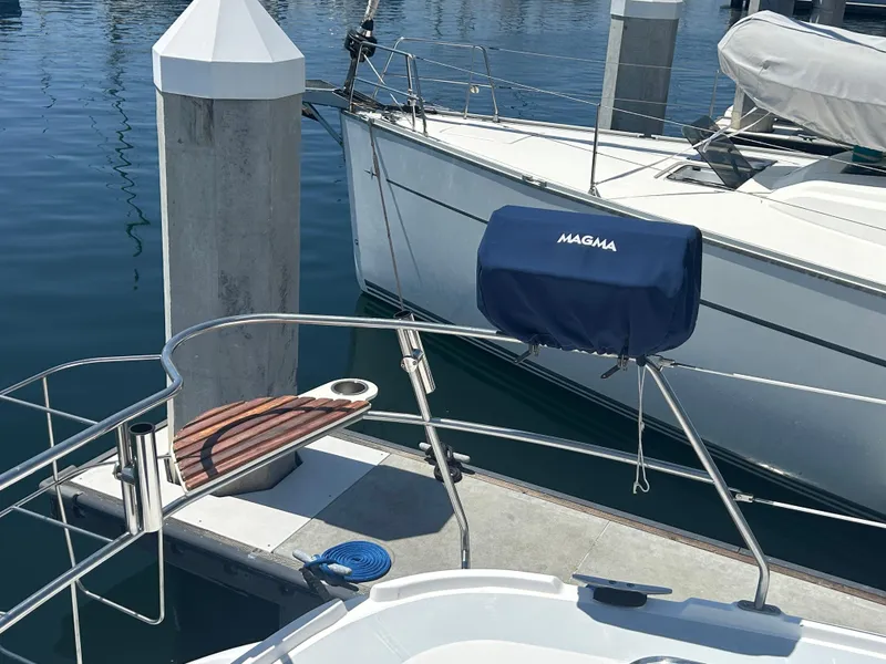 Slide: The Image of Hunter Passage 450 sailboat docked, featuring a Magma grill and wooden step, 1998 model. - 2