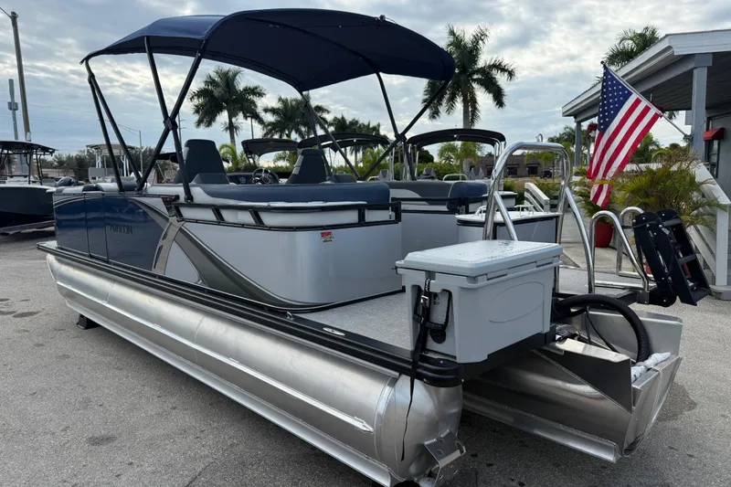 Slide: The Image of 2025 Avalon LSZ Quad Lounger 24' Tri Toon boat with canopy and American flag. - 33