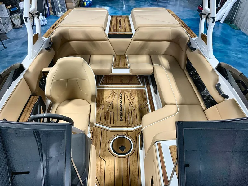 Slide: The Image of 2025 Moomba Mondo boat interior with tan seating and wood accents. - 12