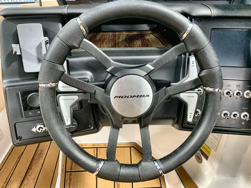 Slide: The Image of Steering wheel of 2025 Moomba Mondo boat with control panel and switches. - 14