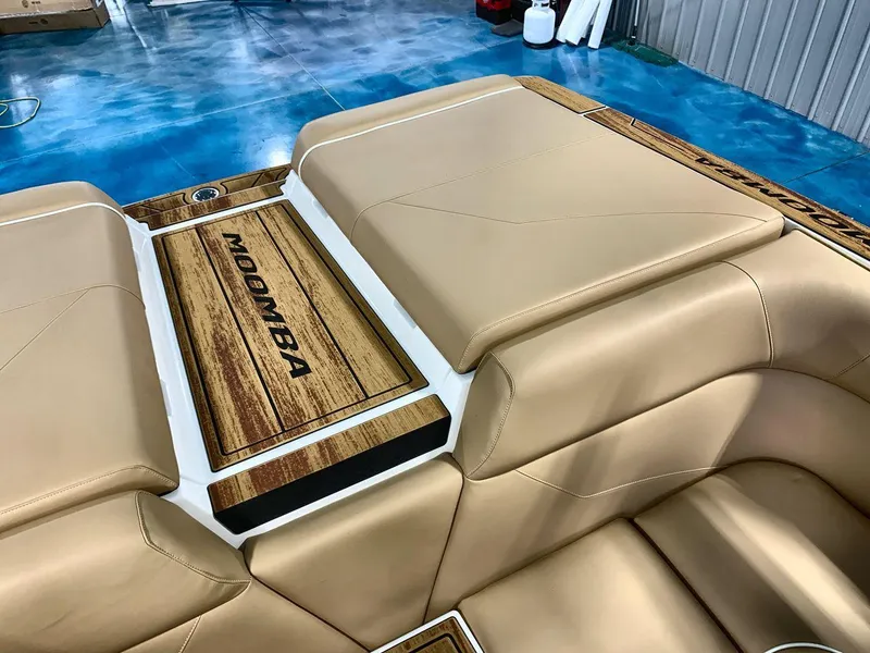 Slide: The Image of 2025 Moomba Mondo boat interior with tan leather seating and wood accents. - 19