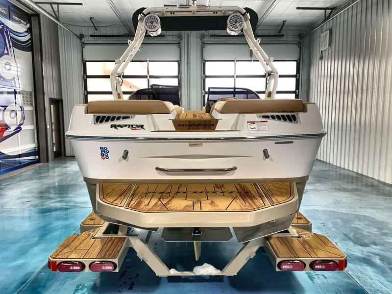 Slide: The Image of 2025 Moomba Mondo boat in a garage, showcasing rear design and teak swim platform. - 4