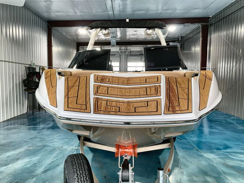 Slide: The Image of 2025 Moomba Mondo boat in a garage, featuring a sleek design and wooden accents. - 8