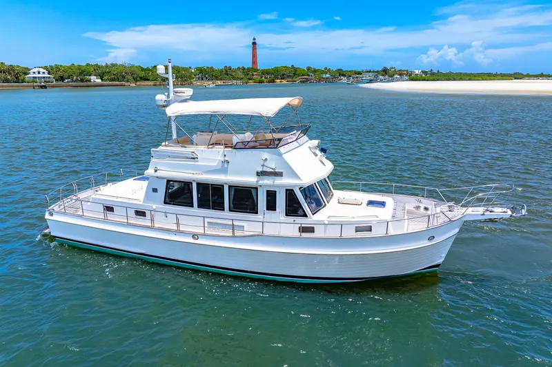 Slide: The Image of 2008 Grand Banks 47 Classic yacht cruising on a sunny day near a lighthouse. - 1