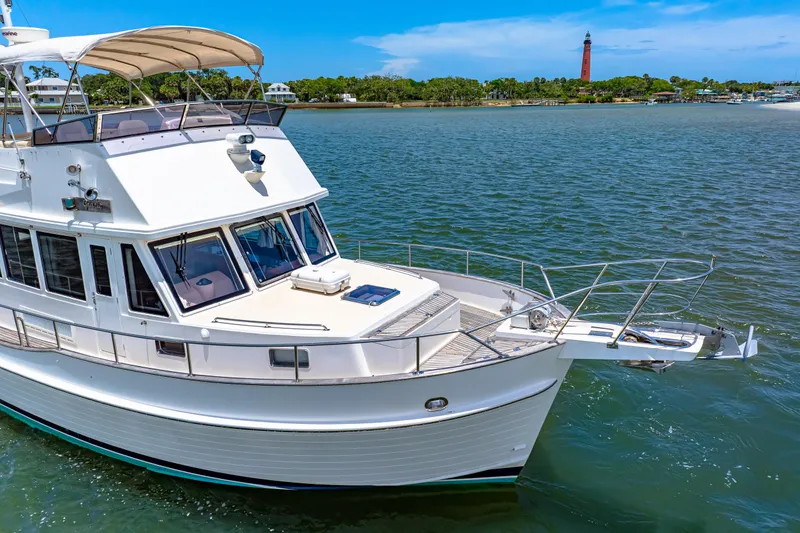 Slide: The Image of 2008 Grand Banks 47 Classic yacht cruising on a sunny day near a lighthouse. - 11