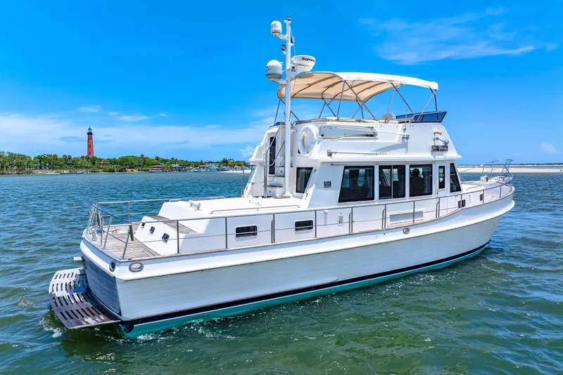 Slide: The Image of 2008 Grand Banks 47 Classic yacht cruising near a lighthouse on a sunny day. - 14