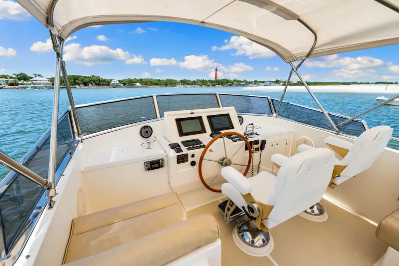 Slide: The Image of 2008 Grand Banks 47 Classic yacht helm with dual seats, steering wheel, and navigation equipment. - 35