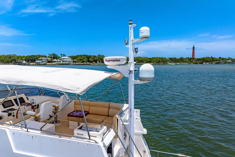 Slide: The Image of 2008 Grand Banks 47 Classic yacht with Raymarine equipment, cruising near a lighthouse. - 4