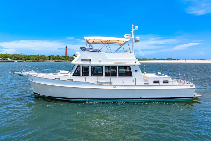 Slide: The Image of 2008 Grand Banks 47 Classic yacht cruising on a sunny day near a lighthouse. - 5