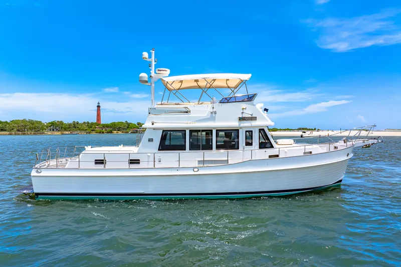 Slide: The Image of 2008 Grand Banks 47 Classic yacht cruising on a sunny day near a lighthouse. - 9