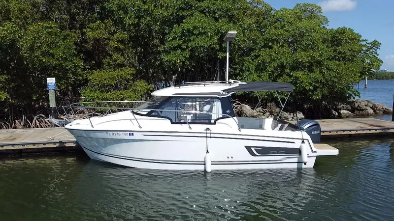 Slide: The Image of 2023 Jeanneau NC Weekender 795 Series 2 docked by lush greenery. - 1