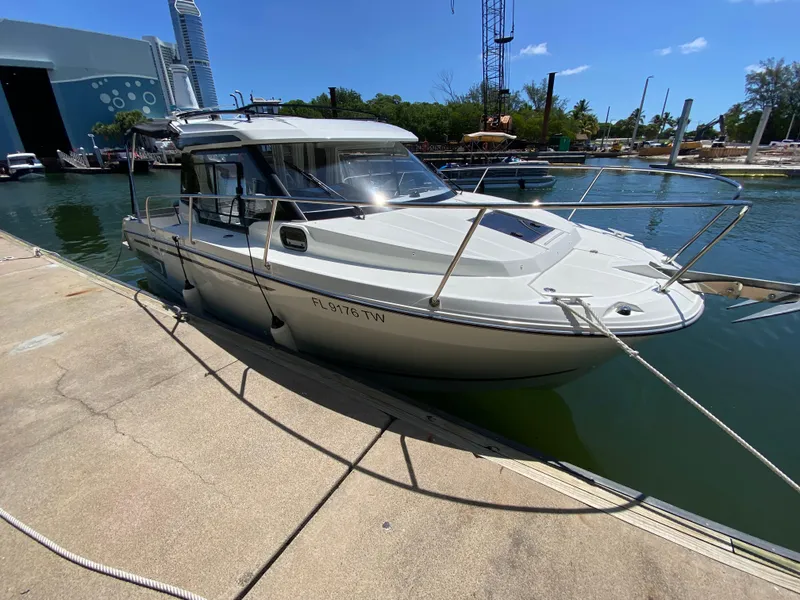 Slide: The Image of 2023 Jeanneau NC Weekender 795 Series 2 docked at marina under clear blue sky. - 13