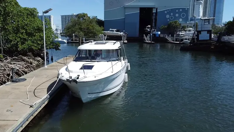 Slide: The Image of 2023 Jeanneau NC Weekender 795 Series 2 docked at marina, surrounded by water and trees. - 2