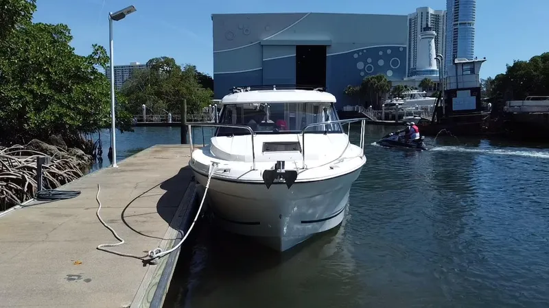 Slide: The Image of 2023 Jeanneau NC Weekender 795 Series 2 docked at marina with cityscape background. - 5