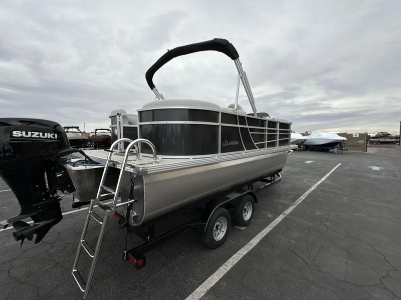 Slide: The Image of 2025 Landau Island Breeze 19 C pontoon boat with Suzuki motor on trailer. - 5