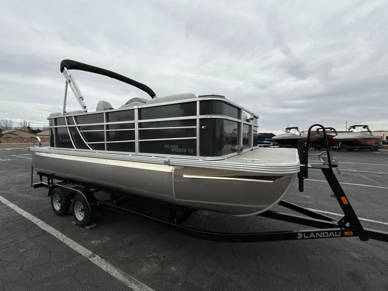 Slide: The Image of 2025 Landau Island Breeze 19 C pontoon boat on trailer, parked outdoors. - 7