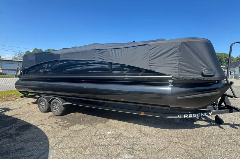 The Image of 2025 Regency 250 LE3 Sport boat covered on a trailer under clear blue sky. - 0