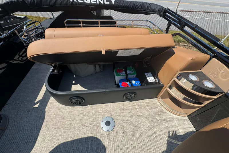 Slide: The Image of 2025 Regency 250 LE3 Sport boat interior with open storage compartment and batteries. - 10