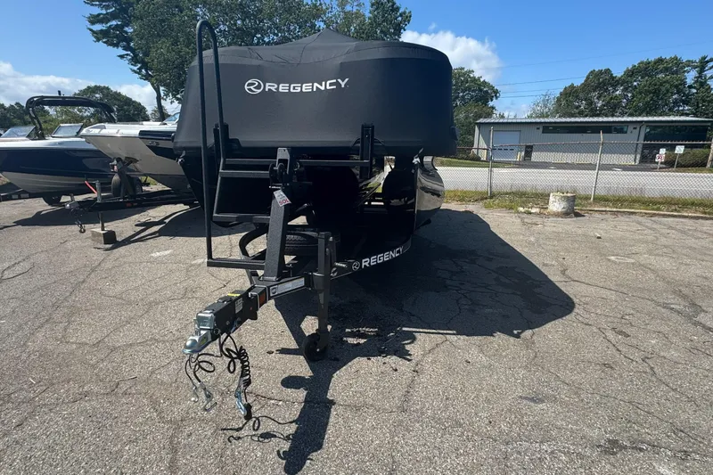 Slide: The Image of 2025 Regency 250 LE3 Sport boat on trailer, covered, parked outdoors. - 2