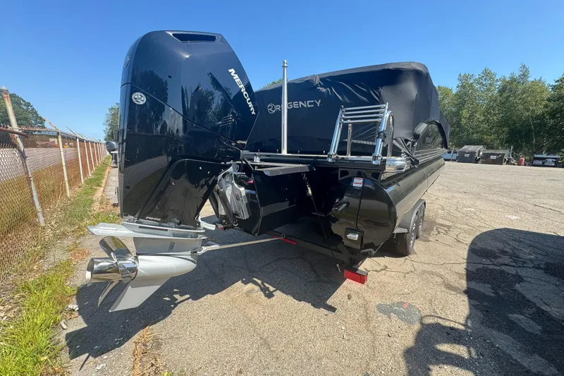 Slide: The Image of 2025 Regency 250 LE3 Sport boat with Mercury engine, parked outdoors on a sunny day. - 3