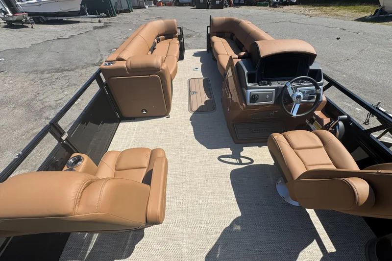 Slide: The Image of 2025 Regency 250 LE3 Sport pontoon boat with tan leather seating and modern dashboard. - 6