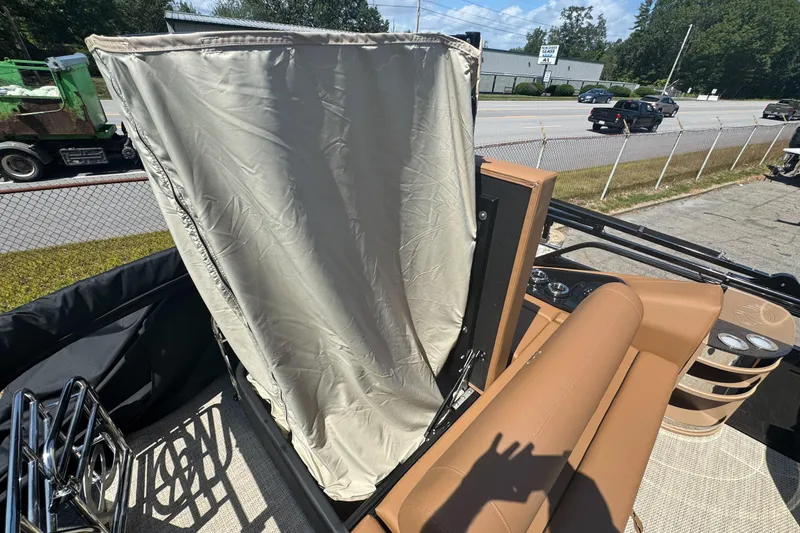 Slide: The Image of 2025 Regency 250 LE3 Sport boat interior with beige seating and privacy curtain. - 8