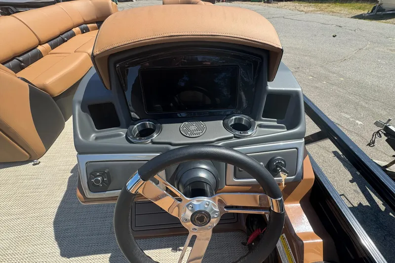 Slide: The Image of 2025 Regency 250 LE3 Sport boat dashboard with steering wheel and seating. - 9