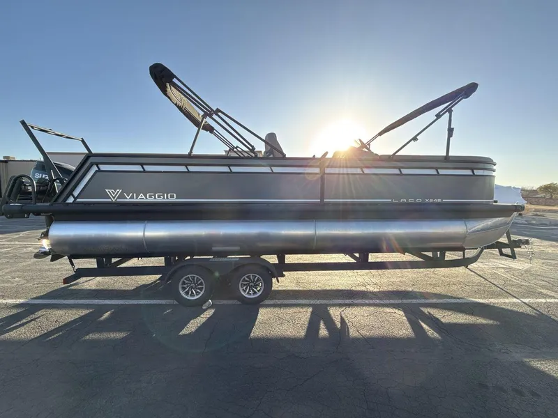 Slide: The Image of 2025 Viaggio x24s pontoon boat on trailer, sunlit background. - 6